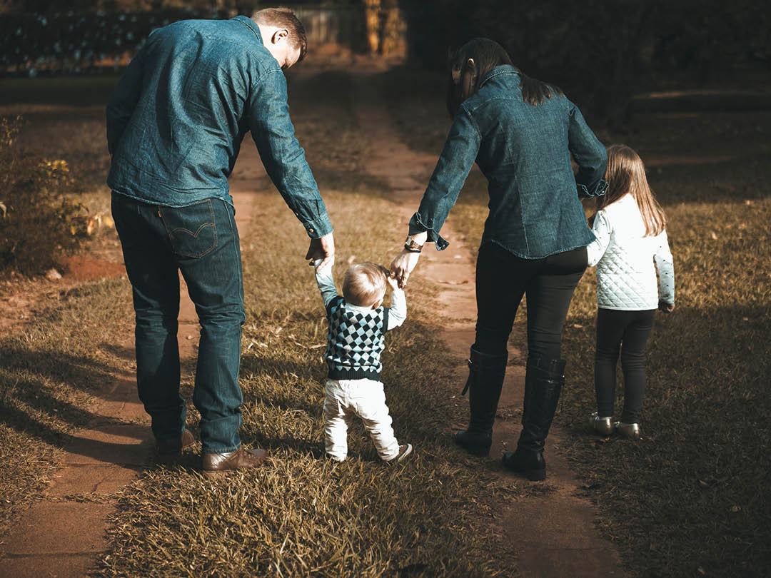 Parents with two children walking in a park